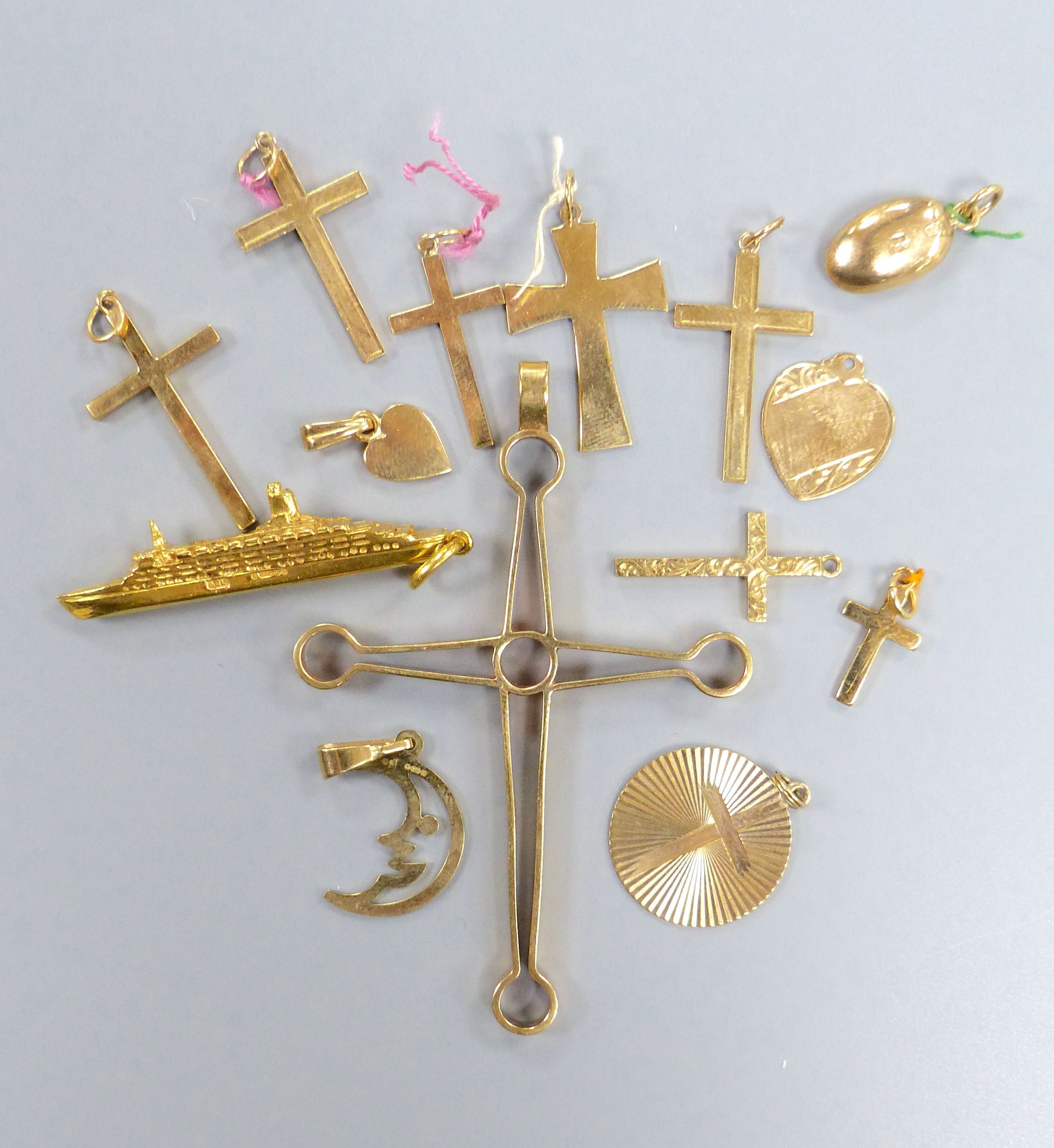 Fourteen assorted 9ct gold pendants including heart, QEII ship and crosses, largest 67mm,